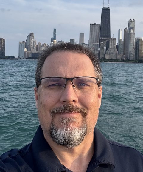 Cory Cowgill on Lake Michigan with the Chicago skyline behind him